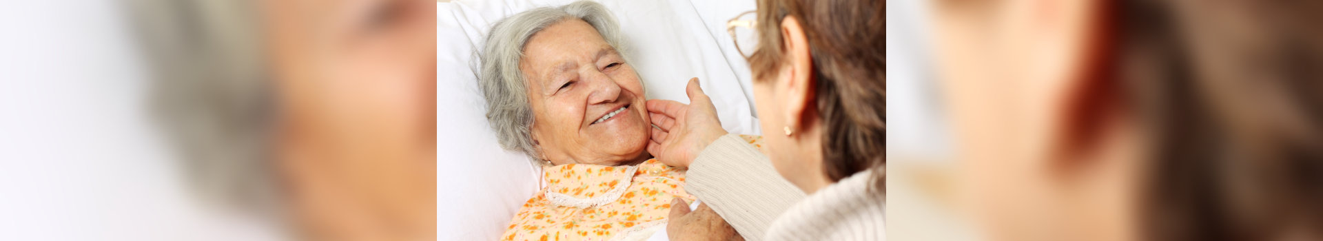 caregiver caressing old woman's face