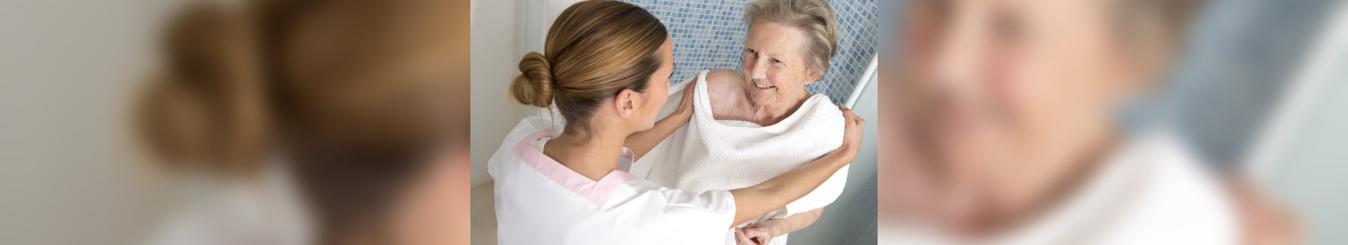 caregiver assisting old woman in taking a bath